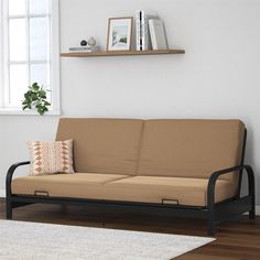 a living room scene with focus on the futon and pillows, along with bookshelves