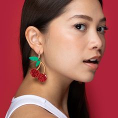 These awesome Cherry dangles are cute, kitsch and sophisticated all at once! Crafted in-house from glitter and pearl acrylic and hand-stained wood, they brighten up any outfit day or night.  The cherries hang and sway from elegant 22mm gold-filled hoops, and are removable so you can wear the hoops on their own—two earrings in one, perfect for travel! Wipe clean with a damp cloth. Do not submerge in water. Keep away from extreme heat. Red Resin Novelty Earrings, Cherry-colored Jewelry For Valentine's Day Party, Cherry Colored Jewelry For Valentine's Day Party, Cherry Color Jewelry For Valentine's Day Party, Cherry Jewelry For Valentine's Day Party, Whimsical Red Party Jewelry, Cherry Colored Earrings For Summer Party, Cherry Color Earrings For Summer Party, Earring Charm