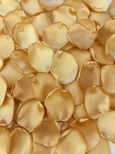 a pile of gold colored petals on a white surface