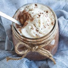 a glass jar filled with whipped cream on top of a blue towel