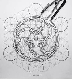 some scissors are laying on top of an intricately designed design with circles and spirals