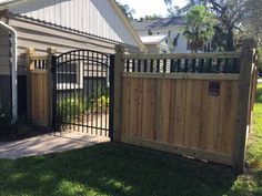 a wooden fence and gate in front of a house