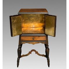 an old wooden desk with gold paint on the top and drawer open to reveal its contents