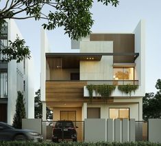 a car is parked in front of a modern building with balconies on the second floor