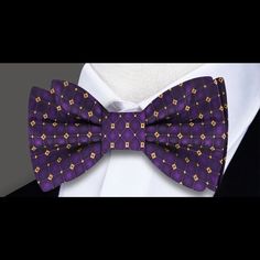 Radiant Royalty: The Purple and Gold Geometric Silk Bow Tie Step into the world of regal elegance with our Purple and Gold Geometric Silk Bow Tie. A true masterpiece, this bow tie boasts a captivating geometric pattern that effortlessly marries the richness of purple with the opulence of gold. Whether you choose the self-tie or pre-tied option, this accessory is a statement piece that will elevate your style to royal heights. Let's explore the details that make this bow tie a crown jewel in the Elegant Purple Bow Tie For Party, Elegant Purple Party Ties, Purple Bow Tie For Party, Elegant Bow With Butterfly Knot For Black-tie Events, Elegant Pre-tied Bow For Gift, Purple Party Bow Tie, Elegant Fitted Multicolor Bow Tie, Elegant Multicolor Bow Tie, Elegant Fitted Bow For Gift