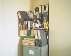 there are many files and folders stacked on top of each other in a filing cabinet