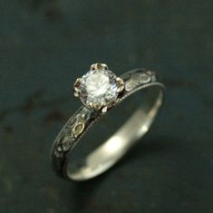 a white diamond ring sitting on top of a table