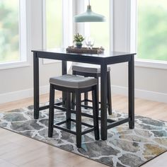 a table with two stools in front of it and a rug on the floor