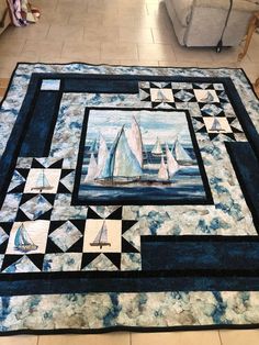 a quilt with sailboats on it sitting on the floor