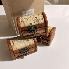 two wooden trunks with maps on them sitting next to a cardboard box