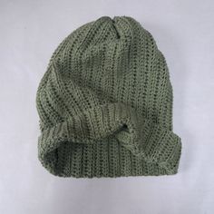 a green knitted beanie on a white background