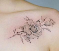 a woman's chest with a rose tattoo on the left side of her breast