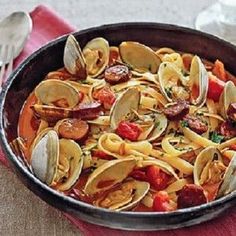 a skillet filled with pasta and clams