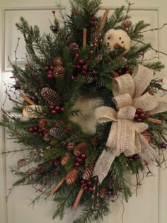 a christmas wreath with pine cones and other decorations