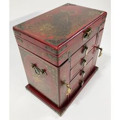 an old wooden box with ornate designs on the top and bottom, sitting on a white surface