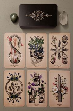 six playing cards with different designs on them next to a knife and some glassware