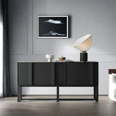 a black and white sideboard with a lamp on it in a living room setting