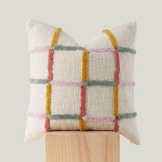 a white pillow with multicolored squares on it