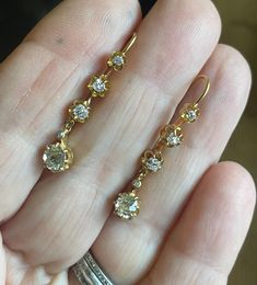 18k Buttery Yellow Gold Victorian Earrings from Paris, France Circa 1870's Buttercup settings 10 clean white sparkly old cut diamonds ( thicker/  smaller table total: 2 Bottom Old Cut Diamonds Cushion Cut Oval 3.95 x 4.25mm estimated @ .30ct = .60ct  2@ .08 cushion cut= .16ct. 2@ .06ct. cushion cut = .12ct. 2@.03ct. cushion cut = .06ct. 2@ .015ct. = .03ct. bezel set Estimated total weight .97ct. just under 1ct.  2.7grams 1 1/4" length  EXCELLENT CONDITION Victorian- The Victorian era is generall Victorian Brilliant Cut Diamond Earrings For Anniversary, Victorian Style Round Diamond Earrings For Formal Occasions, Victorian Diamond Earrings With Prong Setting For Anniversary, Antique Round Diamond Anniversary Earrings, Vintage Yellow Gold Diamond Earrings With Rose Cut, Antique Round Diamond Earrings For Anniversary, Vintage Gold Diamond Earrings With Brilliant Cut, Vintage Round Diamond Earrings, Classic White Diamond Earrings With Rose Cut