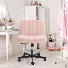 a pink office chair sitting on top of a wooden floor next to a white desk