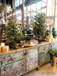 christmas trees are sitting on top of an old dresser