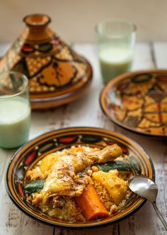 there is a plate with food on it next to two glasses and a glass of milk