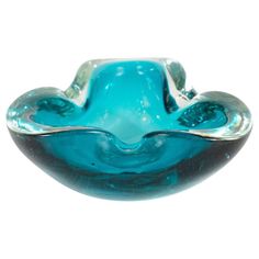 a blue glass bowl sitting on top of a white table