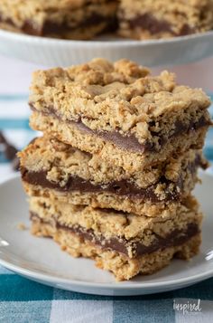 three pieces of chocolate chip cookie bars stacked on top of each other in front of another plate