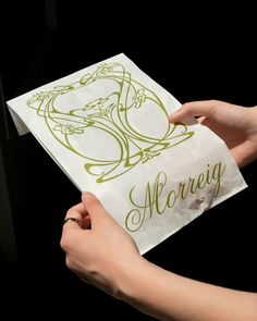 a person holding up a piece of paper with the word moronig on it