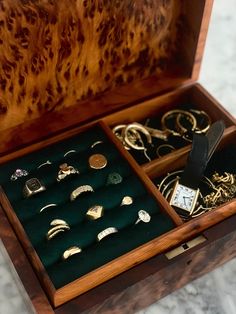 a wooden box filled with lots of different types of rings