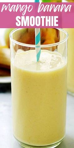 mango banana smoothie in a glass with a straw