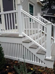 a white porch with steps leading up to the house