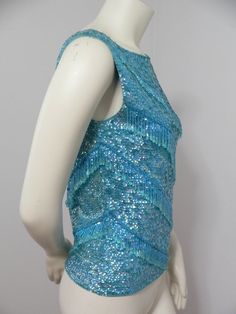 a mannequin wearing a blue top with sequins on it