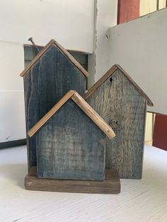 two small wooden houses sitting on top of a table