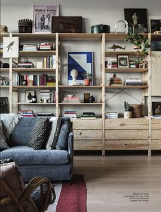 a living room filled with furniture and bookshelves next to a wall full of shelves