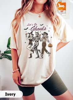 Embrace the spooky season with our Let's Go Ghouls T-shirt , Western Halloween Shirt, a unique Comfort Colors tee perfect for any cowgirl and for Halloween Party. This Wild West Witch shirt makes an ideal Halloween gift, blending Western charm with festive fun for the ultimate Halloween T-shirt. Welcome to Gift Vibe Shop - Your Fashion Wonderland! **SIZING** The shirts are unisex and run true to size, but size up for a more oversized fit. Please refer to the photo cards for a detailed size guide Spooky Cotton Tops For Costume Party, Short Sleeve Top With Letter Print For Costume Party, Spooky Short Sleeve Tops For Costume Party, Spooky Cotton Top For Costume Party, Cotton Graphic Print Top For Costume Party, Cotton Crew Neck Top For Costume Party, Horror Graphic Print Top For Costume Party, Casual Graphic Print Top For Costume Party, Cotton Tops With Letter Print For Costume Party