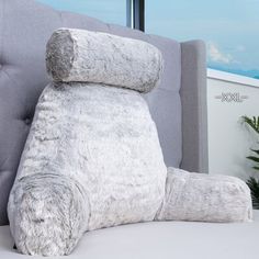 a large stuffed animal sitting on top of a gray couch next to a tall window