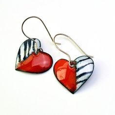 two red and white heart shaped earrings with silver earwires on a white background