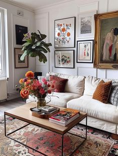 a living room filled with lots of furniture and pictures on the wall above it's coffee table