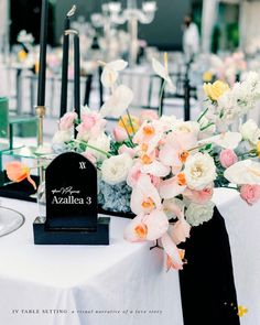 an arrangement of flowers and candles on a table at a wedding reception with the name azzana 3 written on it