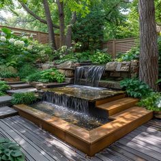 a small waterfall in the middle of a wooden deck surrounded by greenery and trees