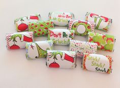 small candy wrappers with different designs on them sitting on a white surface, one is green and the other is red