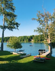 several canoes are docked on the shore of a lake