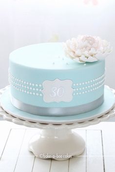 a blue cake with white flowers on top