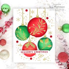 a christmas card with ornaments hanging from it and the words season's greetings