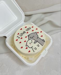 a cake in a plastic container with the words i love you on it and an elephant