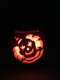 a carved pumpkin with the shape of a cat on it's face in the dark