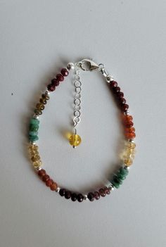 This Fall colored bracelet has 5 different gemstones with Sterling Silver beads and findings. They are Ruby, Carnelian, Citrine, Emerald and Tourmaline. It has a 1" extension with a beaded drop and a lobster claw clasp.  Custom orders are welcome! Ask about free sizing. Amber Beaded Bracelets For Healing, Spiritual Multicolor Faceted Beaded Bracelets, Adjustable Amber Gemstone Bracelets, Adjustable Natural Stones Bracelet, Rondelle Gemstones For Jewelry Making, Multicolor Charm Bracelet With Natural Stones And Round Beads, Multicolor Charm Bracelet With Natural Stone Round Beads, Multicolor Charm Bracelet With Round Natural Stones, Multicolor Charm Bracelet With Natural Round Beads