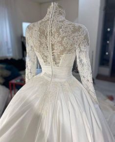 a white wedding dress on display in a room