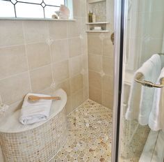 a bathroom with a glass shower door and tiled floor